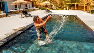 a man standing in the water in a pool at Ethereal Apartments in Agrari