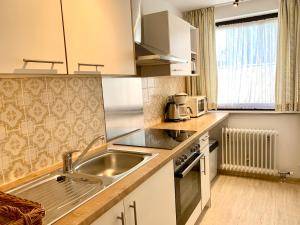 a small kitchen with a sink and a microwave at Birkenhof Apartments in Bad Endorf