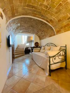 a bedroom with a bed and a stone wall at Grele Dwelling - La Dimora nel Borgo in Guardiagrele