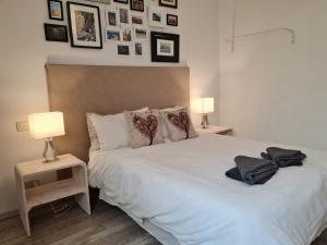 une chambre avec un grand lit blanc avec deux lampes dans l'établissement R1100ERI Ramla Bay by euroresort, à Ix-Xagħra