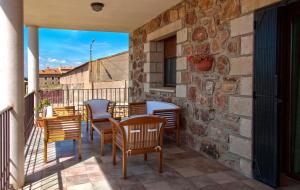 a balcony with chairs and a table on a brick wall at Casa Rural La Dueña in El Pobo de Dueñas