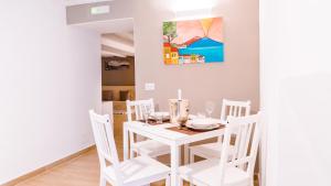 a white dining room with a white table and chairs at Reginella Duomo Apartment in Naples