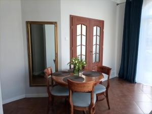 a dining room with a table and chairs and a mirror at Apartament Uzdrowiskowa 7, Świnoujście in Świnoujście