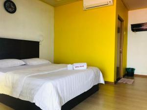 a bedroom with two beds and a yellow wall at Suhaila Palace in Perhentian Islands