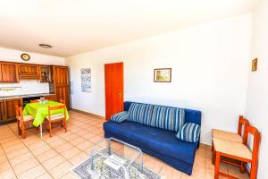 a living room with a blue couch and a table at Apartments Silvia in Novalja