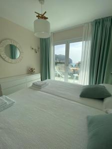 um quarto com uma cama grande e uma janela grande em Sea view apartament 5B with pool 150 Meters Canyamel Beach em Capdepera