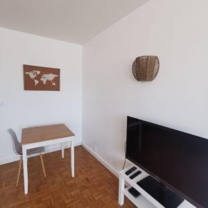 a living room with a table and a tv at Chambre cocooning tout confort Saint Marceau in Orléans