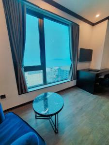 a living room with a glass table and a large window at Kingdom Hotel Cua Lo in Cửa Lò
