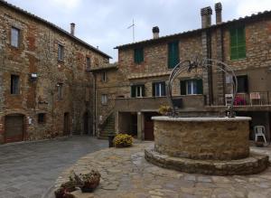 einen steinernen Innenhof mit einem Brunnen vor einem Gebäude in der Unterkunft Bellissima casa dentro il castello di San Savino in San Savino