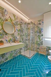 La salle de bains est pourvue d'une douche et d'un sol bleu. dans l'établissement Luxury Suites Casa di Joy in Cefalù, à Cefalù