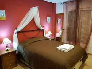 Dormitorio rojo con cama con dosel en Al-Andalus Thalassa, en Vera