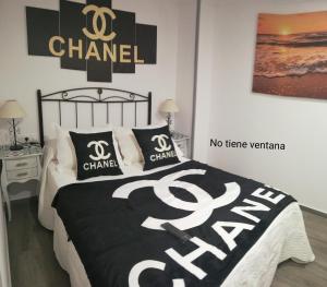 a bedroom with a bed with a black and white comforter at Apartamento SEOANE Bajo in Finisterre