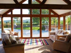 a living room with two couches and a large window at Haimwood Byetake in Llanymynech