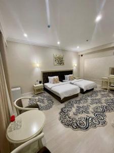a hotel room with two beds and a table at al Madina Hotel Samarkand in Samarkand