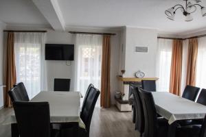 ŞeuşaPensiunea Casa din Vii的一间有桌椅和窗户的餐厅
