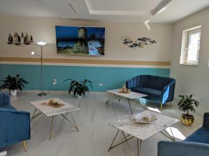 a living room with two tables and two chairs at Il Giglio Marino Cilento Residence by ElodeaGroup in Ascea
