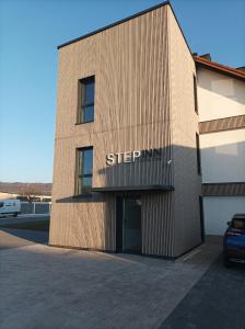 a building with a sign on the side of it at STEP INN The Fair Hotel in Rosbach vor der Höhe