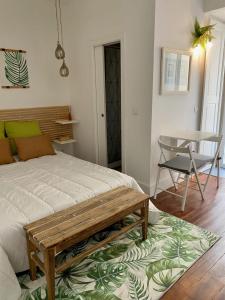 - une chambre avec un lit et un banc sur un tapis dans l'établissement Modern Studio in the Historic Center of Bica, à Lisbonne