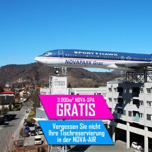an airplane is flying over a city with a sign at NOVAPARK Flugzeughotel Graz in Graz