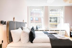 a bedroom with a large bed with white pillows at On The Mile 1 - Into This Place in Copenhagen