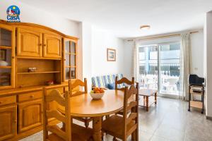 cocina y comedor con mesa de madera en Apartamentos Mare Nostrum Casa Azahar, en Alcossebre