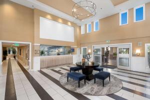 un vestíbulo con una mesa redonda y sillas azules en Best Western Plus Marina Gateway Hotel en National City
