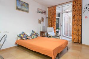 Un dormitorio con una cama con una manta naranja. en Estudio La Colina, en Torremolinos 37 fotos más