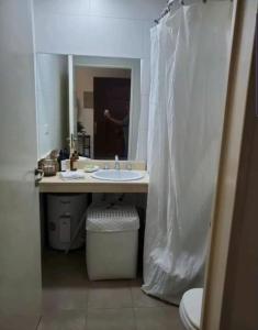 a bathroom with a sink and a toilet and a mirror at pilar tortugas departamento premiun in Del Viso