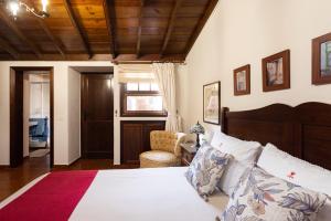 a bedroom with a bed and a chair at Live Casa Rural El Cango in La Degollada