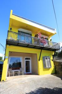 a yellow house with a balcony and a table at 龍坑民宿 in Eluan
