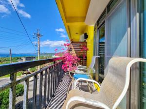 a balcony with a table and chairs and the ocean at 龍坑民宿 in Eluan