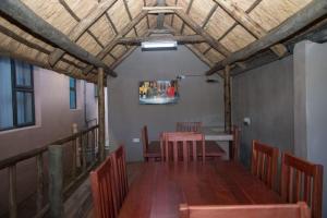 uma sala de jantar com uma mesa e cadeiras e um tecto em 848 Guest House em Victoria Falls