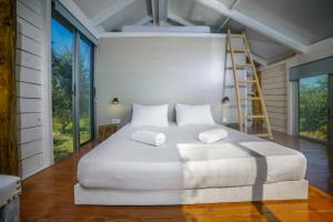 Cama blanca en habitación con escalera en FairyTale en Koukounariá