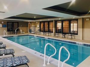 斯特布里奇的住宿－Comfort Inn & Suites Sturbridge-Brimfield，一个带桌椅的大型游泳池