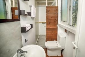 uma casa de banho com um WC branco e um lavatório. em FairyTale em Koukounariá