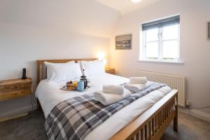 a bedroom with a large bed with towels on it at 15 Mill Field - Aldeburgh Coastal Cottages in Aldeburgh