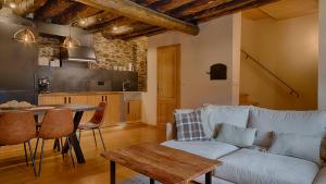 Una sala de estar con un sofá y una mesa y una cocina. en Saplan Real Estate VILAMOS, en Vilamòs
