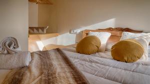 Un dormitorio con una cama con dos almohadas encima. en Saplan Real Estate VILAMOS, en Vilamòs