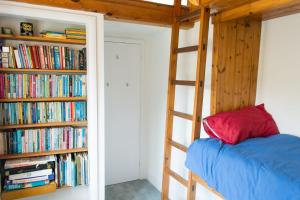 a bedroom with a bunk bed and a book shelf with books at Marlpit Cottage - Norfolk Holiday Properties in Salthouse