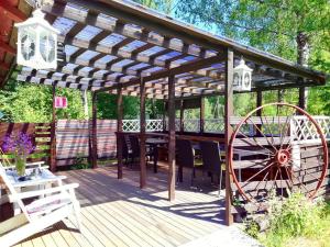 a wooden deck with a pergola and a table and chairs at Saaramaa Camping in Kouvola