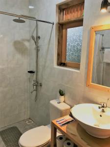 a bathroom with a sink and a toilet and a shower at Kaswa Lodge in Fort Portal