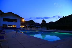 una piscina di fronte a una casa di notte di Les Moineaux a Bellevaux
