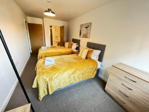 a bedroom with two beds and a dresser at 2 Bedroom, 2 Bathroom Modern Apartment close to Ocean Village, Free parking, Single or Double beds in Southampton