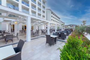 Port River Hotel&Spa في سيدي: فناء خارجي لفندق به طاولات وكراسي