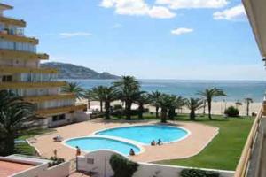 a view of a swimming pool from the balcony of a building at Beautiful apartment in front of beach, pool, view in Roses