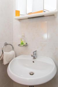 lavabo blanco en el baño con azulejos blancos en Guest House Ljubica, en Dubrovnik