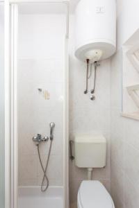Un pequeño baño con inodoro y ducha. en Guest House Ljubica, en Dubrovnik 19 fotos más