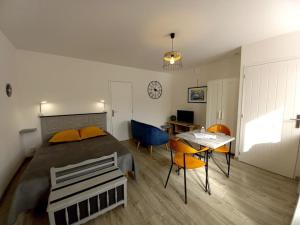Un dormitorio con una cama y una mesa con sillas. en Gîte "Chez Albert et Cie"- 8 mn du Puy du Fou, en Les Herbiers