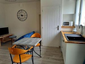 cocina con mesa y sillas y cocina con encimera en Gîte "Chez Albert et Cie"- 8 mn du Puy du Fou, en Les Herbiers