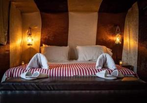 a bedroom with a large bed with slippers on it at Bivouac de luxe Mhamid in Mhamid